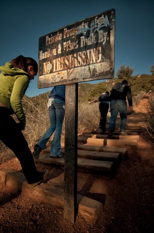  Hikers nonchalantly walk by a "No Trespassing" sign without so much as glancing up.  The Incline was built on land that is owned by three separate entities, the Manitou Springs Cog Railway, The National Forest Service and the city of Colorado Springs - none of these entities will assume liability for injury or usage of the popular hiking trail.  There has been no record of enforcement for trespassing.